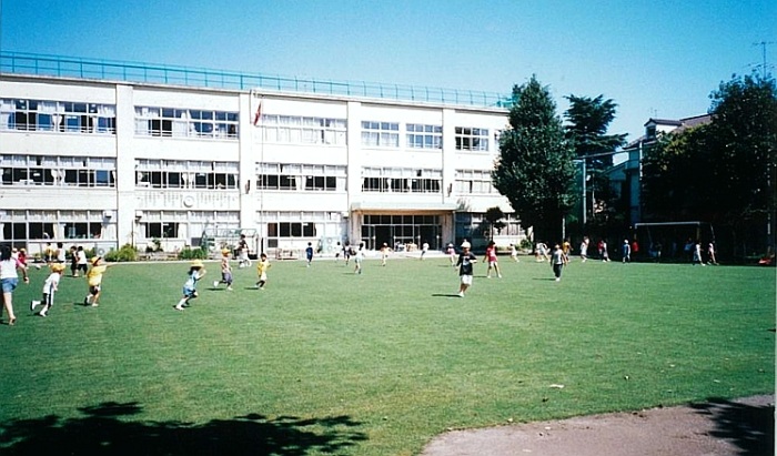 芝生の校庭で遊ぶ生徒たち